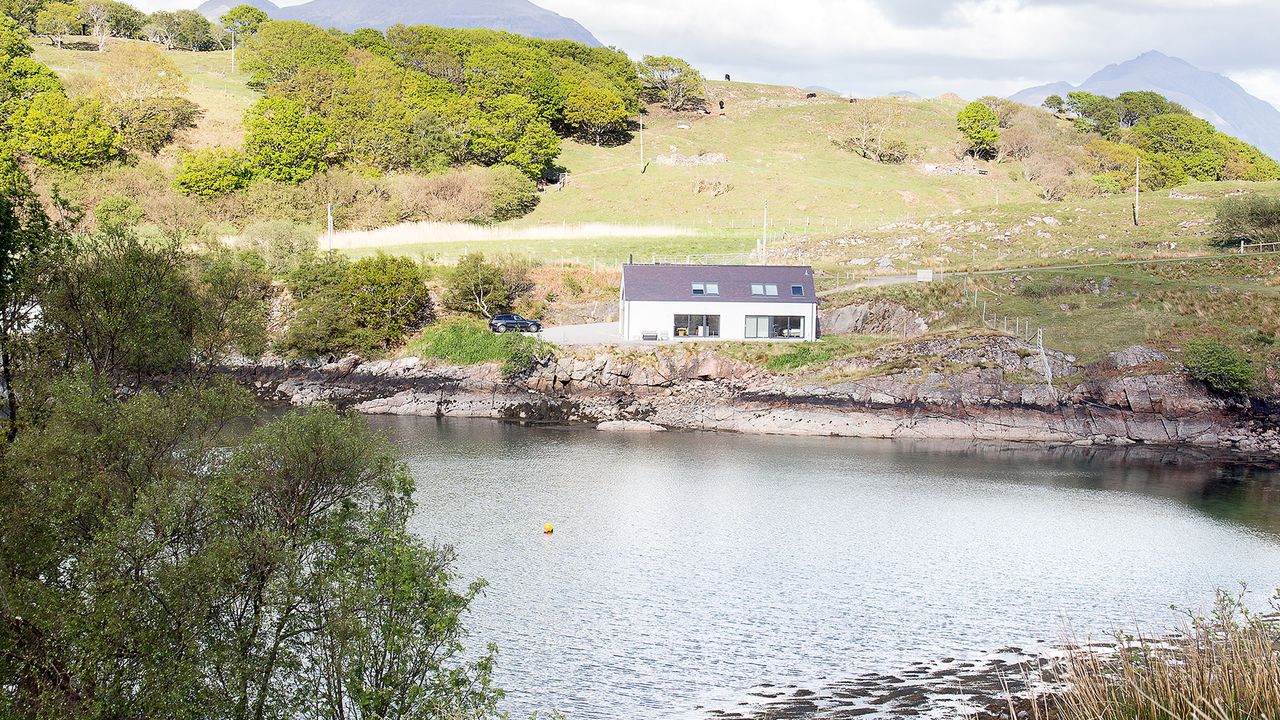 White house next to a lake in countryside