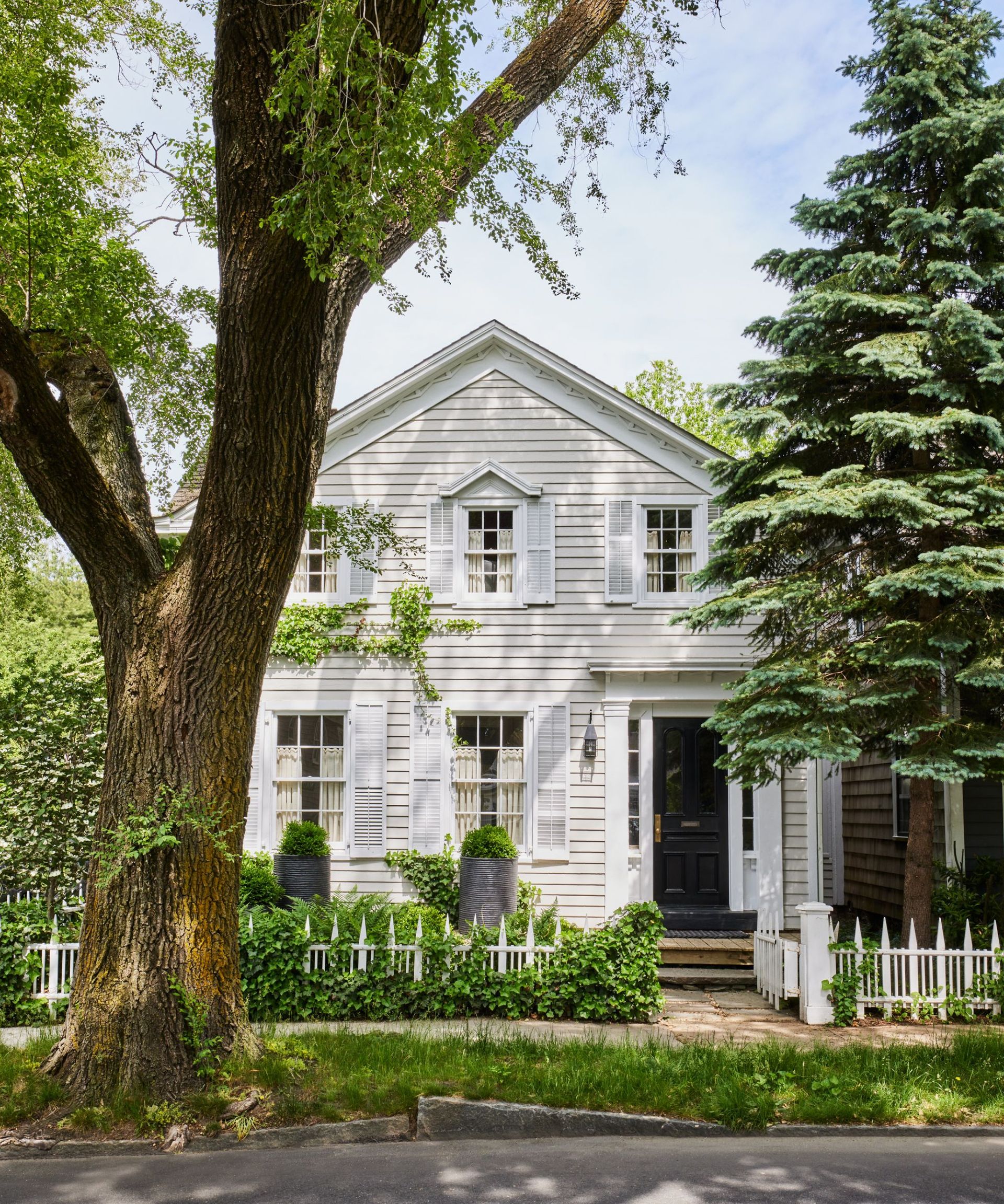 White panelled exterior, shutters, black door