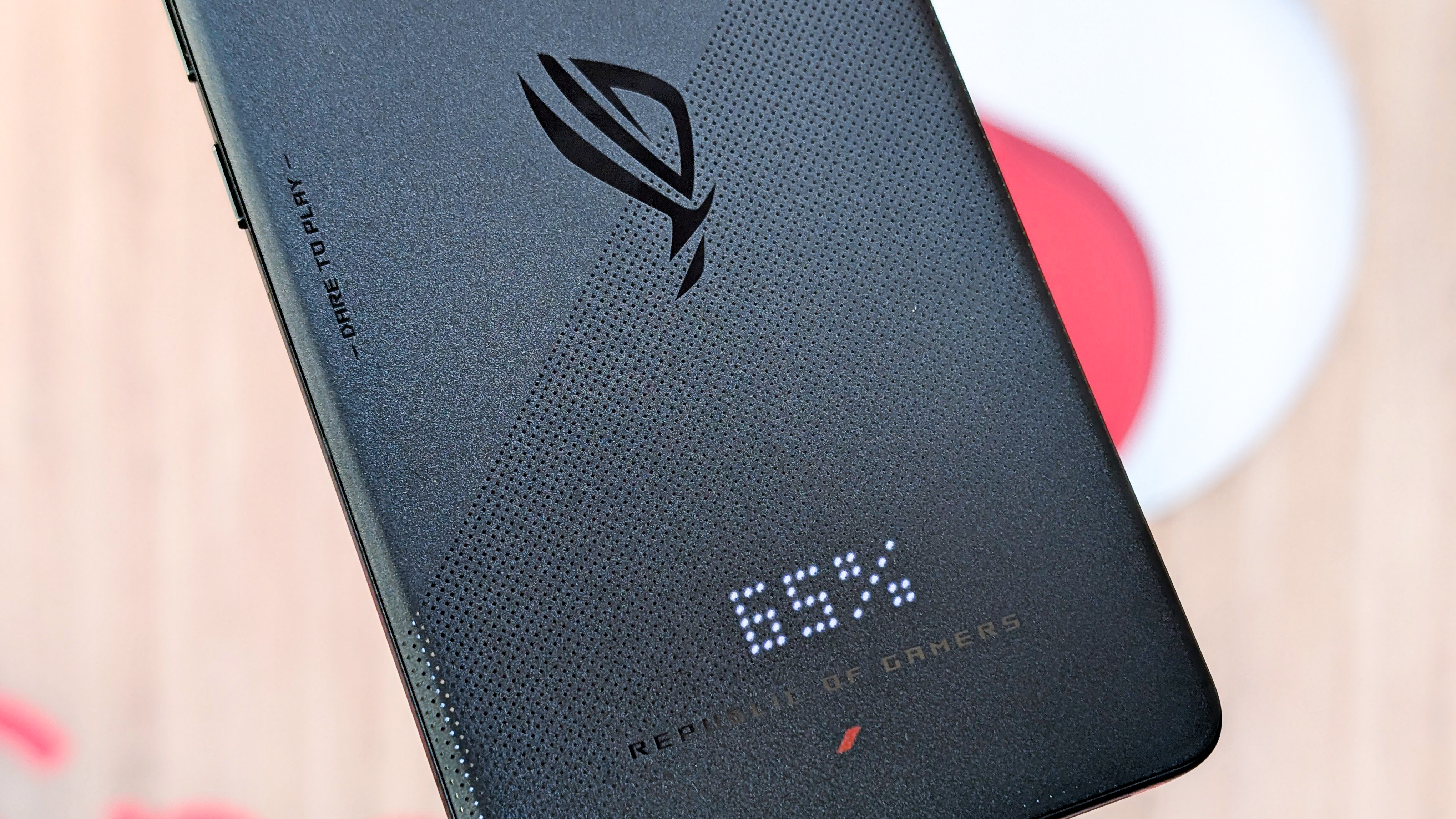 Asus ROG Phone 9 front and back and sides view with Snapdragon logo behind