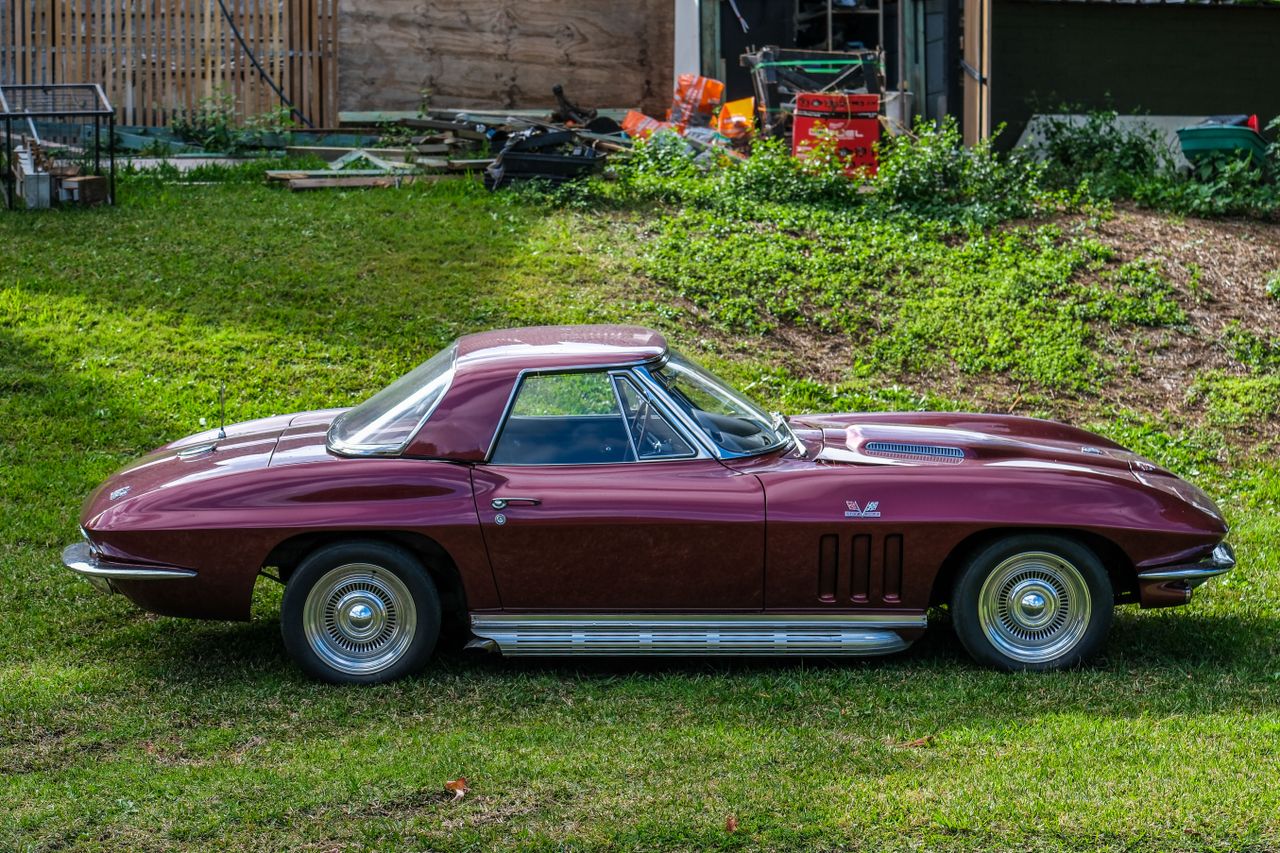 A purple classic car on a grassy verge