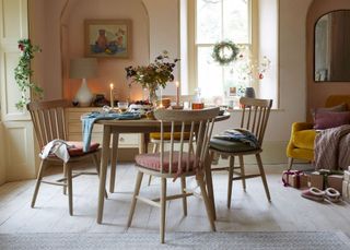 farmhouse dining room with circular wood table and shades of pink and blush