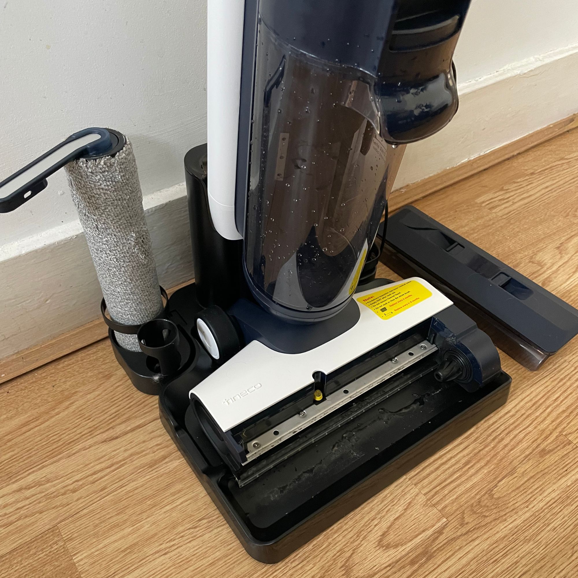 Tineco FLOOR ONE S5 Smart Mop sitting on laminate floor, with the brush roller removed and sitting in the holder