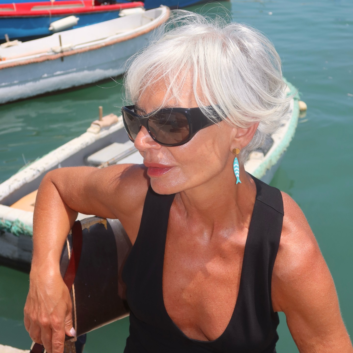 Photo of Grece Ghanem wearing black sunglasses and a tank top