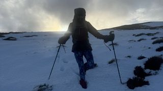 hiking downhill in snow with trekking poles