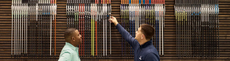 two men selecting golf clubs from the pga tour superstore