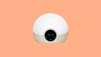 A product shot of a Lumie Alarm clock on an orange background