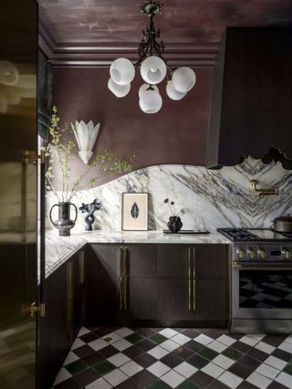 A kitchen with purple walls, marble backsplash and black&white floor tiles