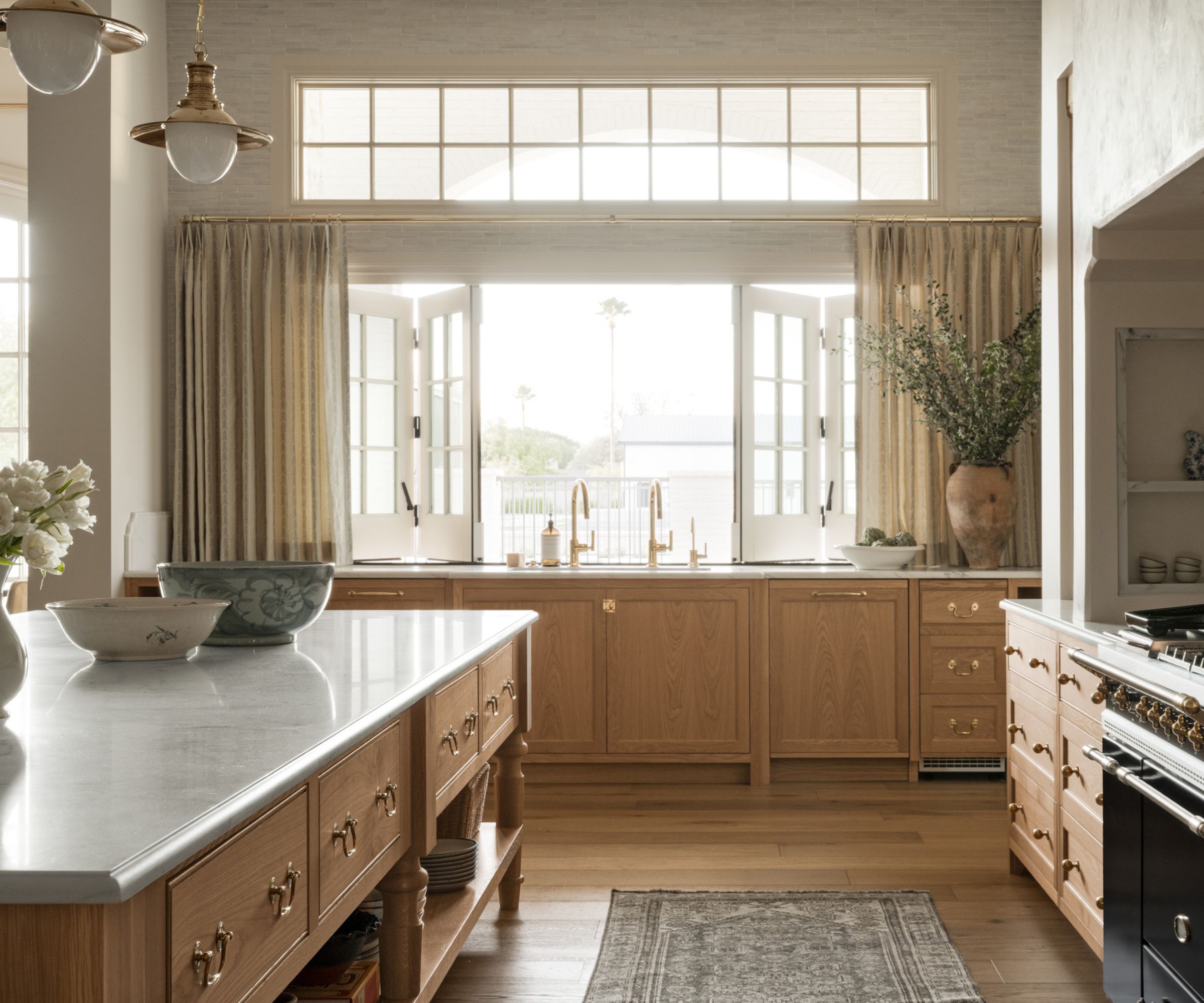 A wooden kitchen with a large pass-through window to the yard