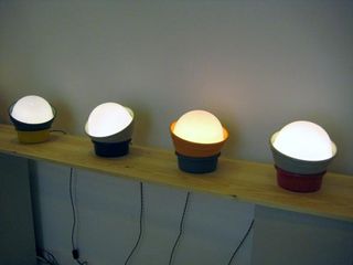 Four table lamps displayed on a wooden surface against white wall