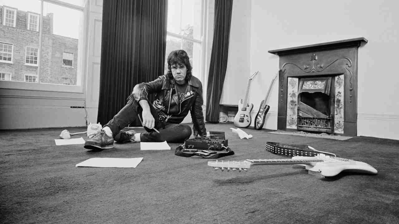 Gary Moore posing for a photograph in an empty room in 1984