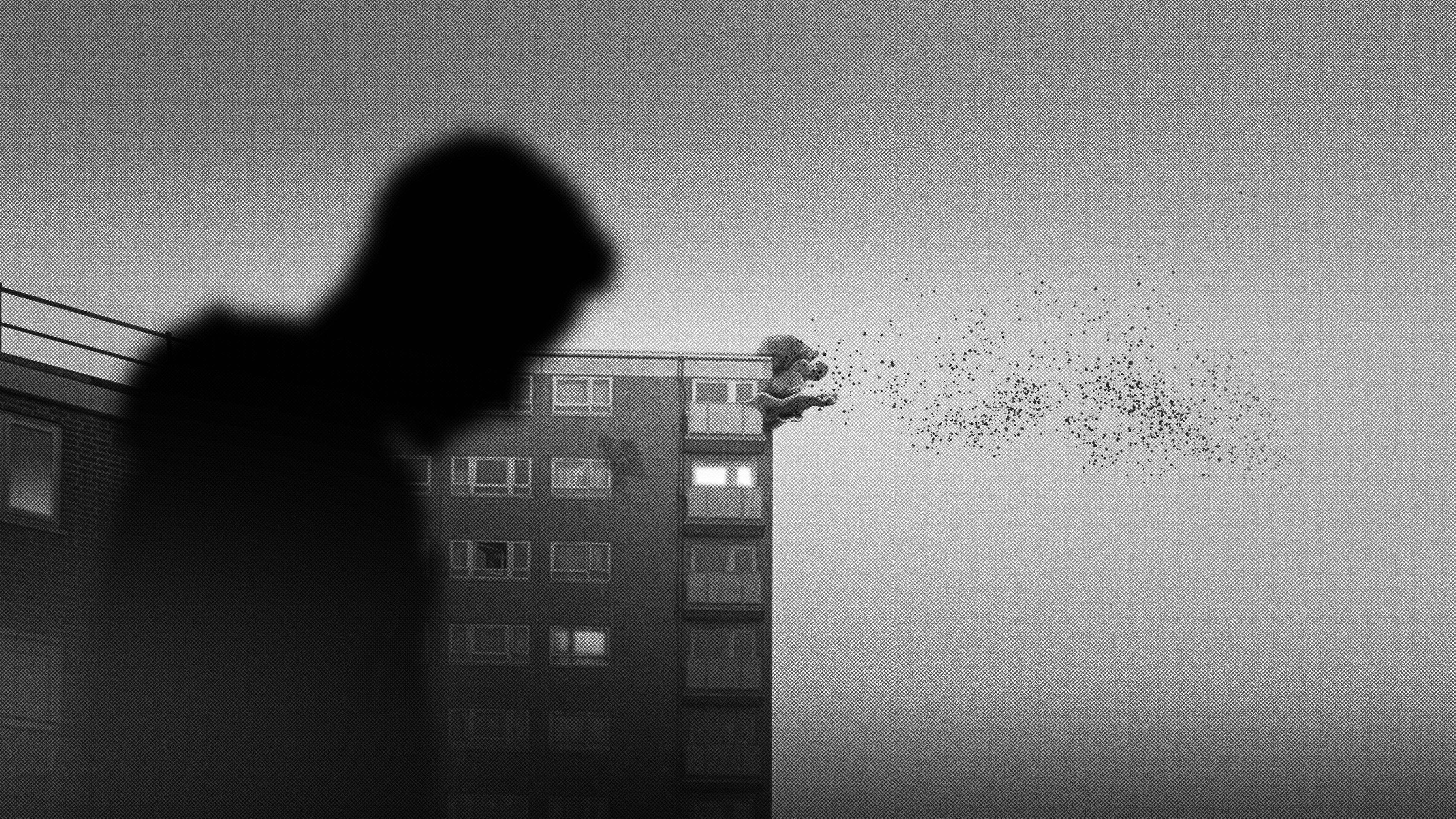 Black and white images from a video game, a city cast in mist, building and people appear as silhouette