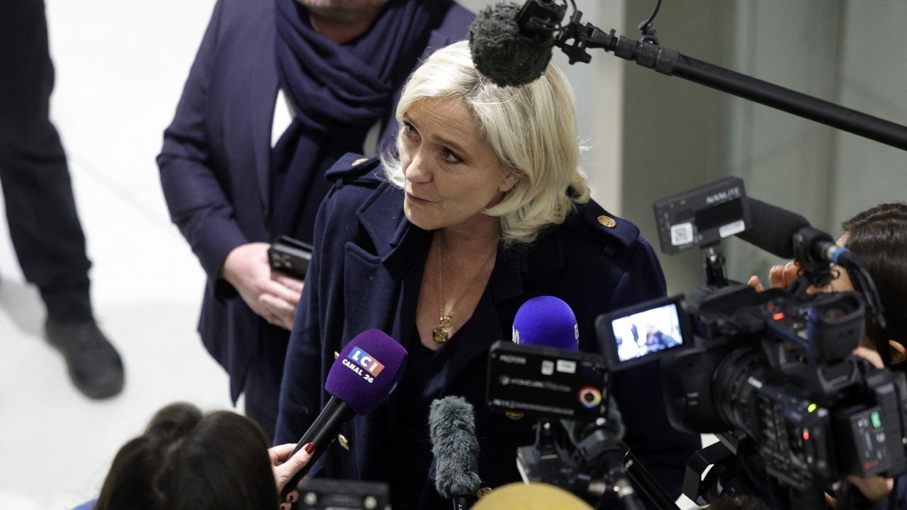 Marine Le Pen talks to the press outside court in Paris