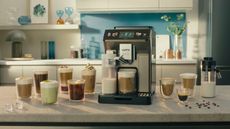 One of the best luxury coffee makers on the market, De'Longhi Eletta Explore on a countertop with coffee around it