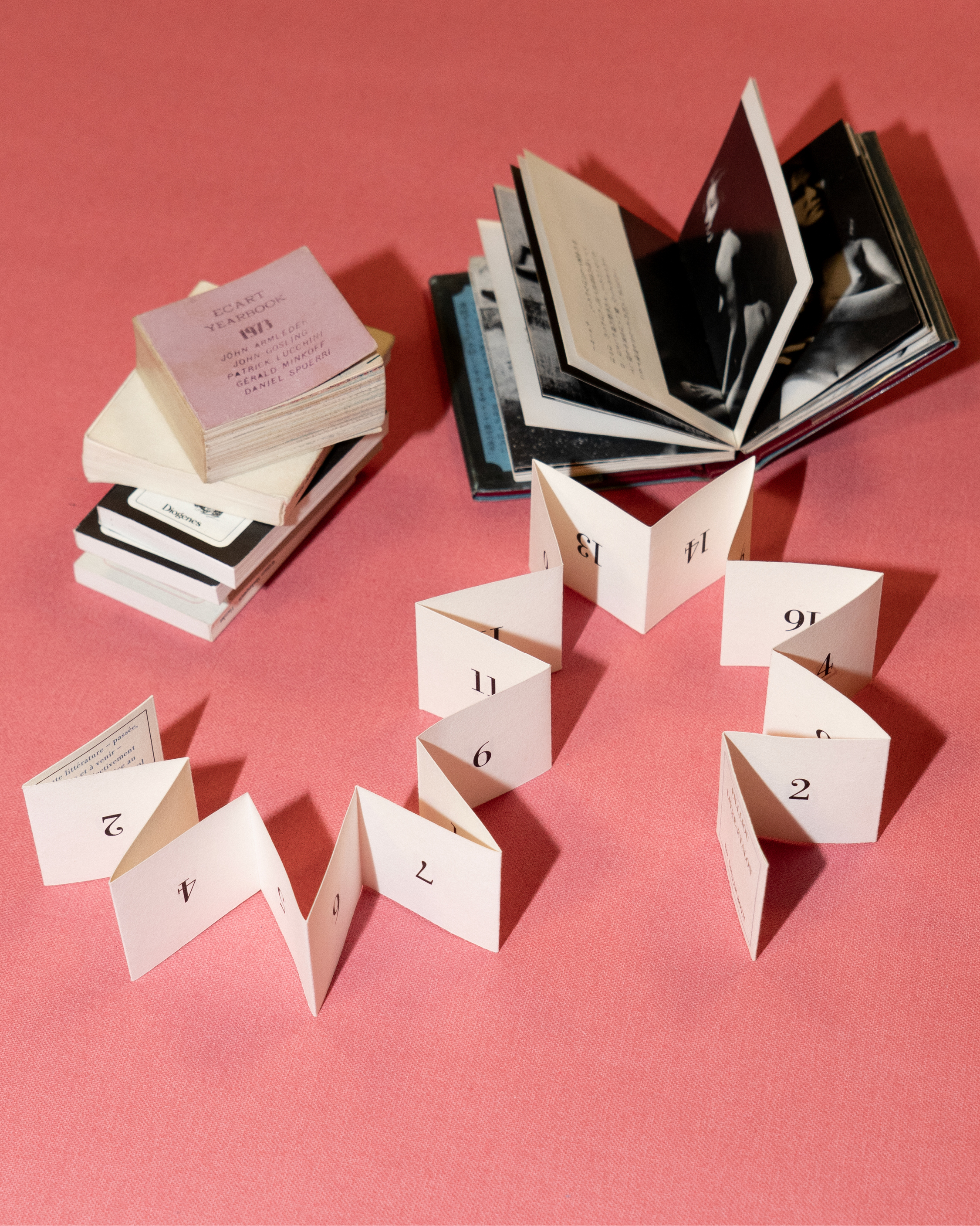 small books arranged across a pink backdrop
