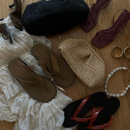 A black raffia clutch, brown heels, tan sandals, red jelly flip-flops, a tan raffia clutch, a beaded necklace, and gold earrings.