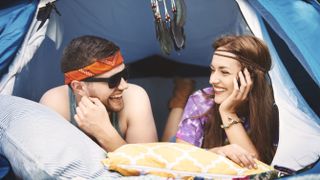 Couple relaxing in a pop-up tent at a festival