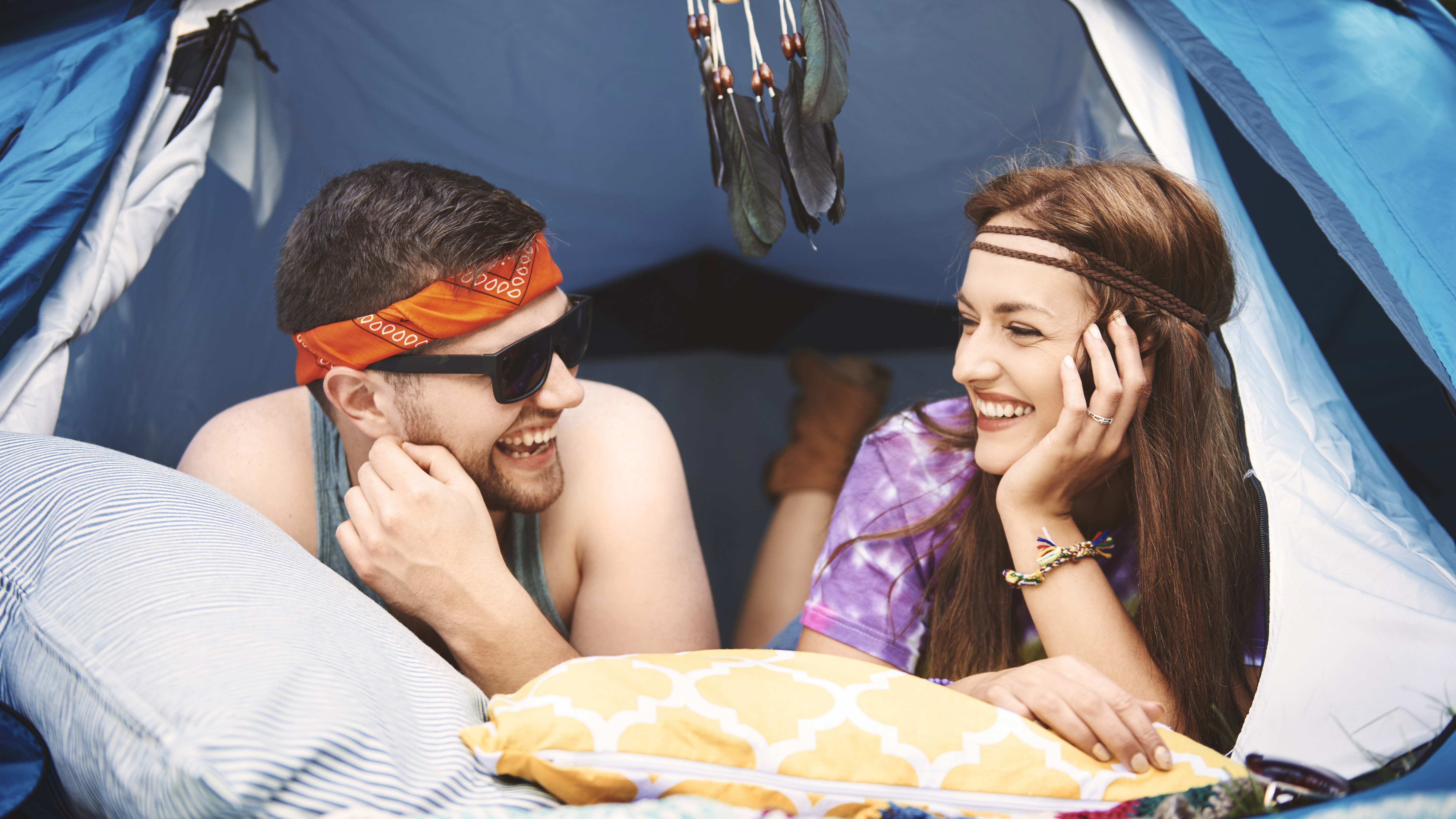 Couple relaxing in a pop-up tent at a festival