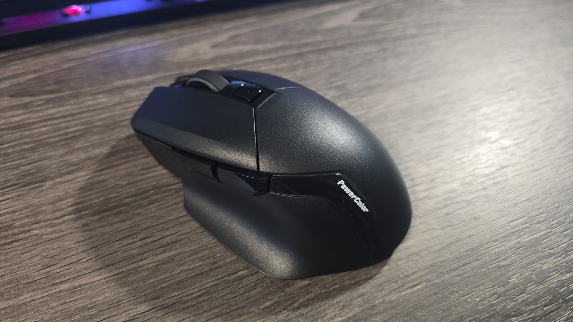 Powercolor Alphyn AM10 Wireless Gaming Mouse with RGB enabled on a desk.