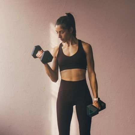 A woman doing a weighted dumbbell workout