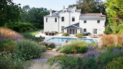 naturalistic style planting on a hillside garden leading down to a pool area