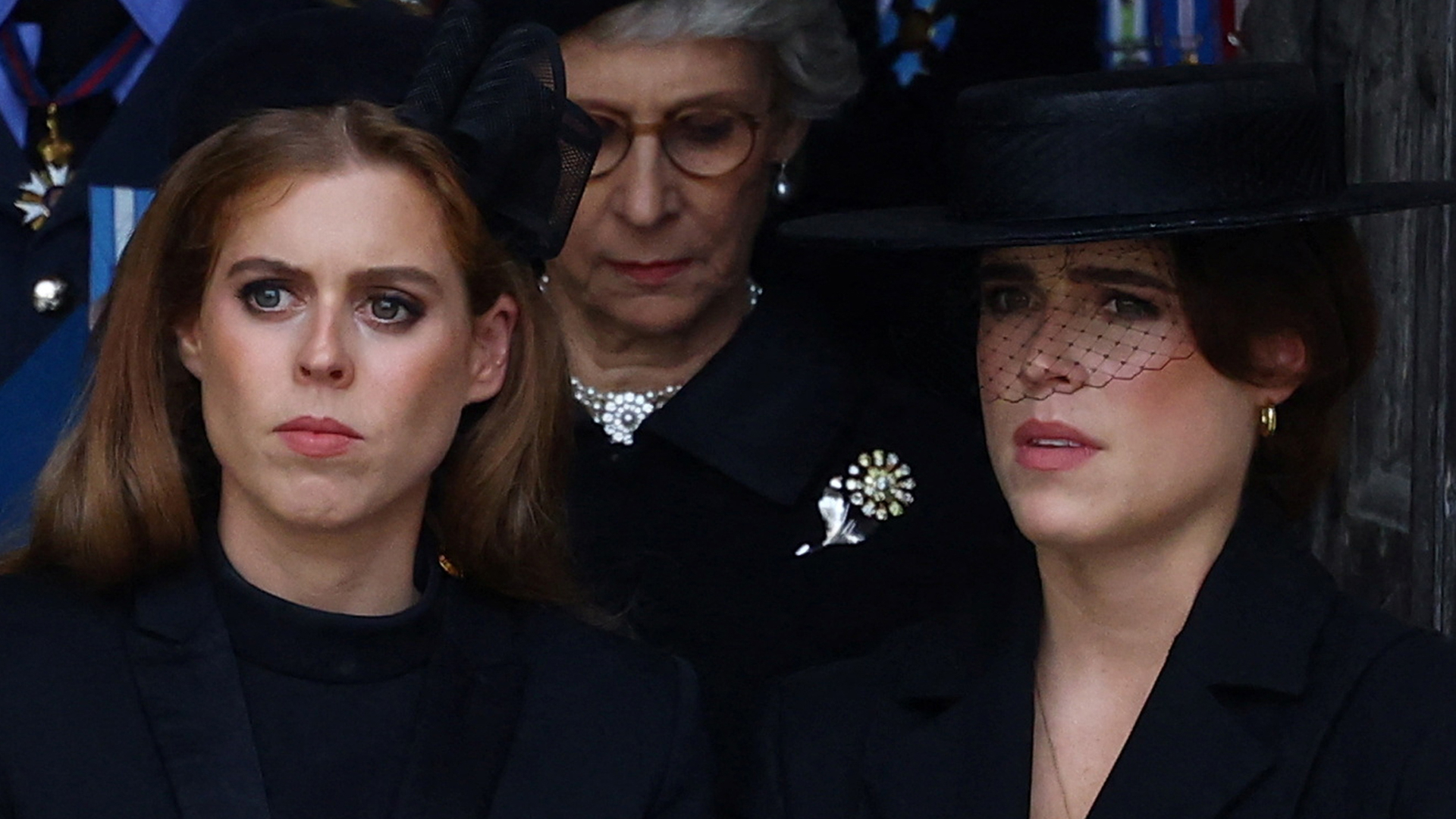 Princess Beatrice and Princess Eugenie both look serious while wearing black outfits