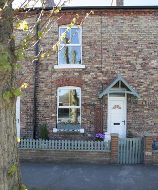 house exterior with brick walls fencing and white door