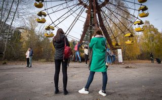 Tourists snap photos in the abandoned city of Pripyat, in the Chernobyl exclusion zone.
