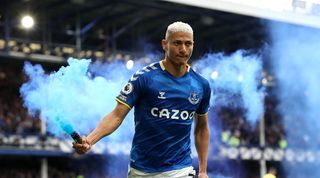 Richarlison celebrates with a flare after scoring for Everton against Chelsea.