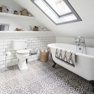 attic bathroom with white wall and black and white pattern tile flooring