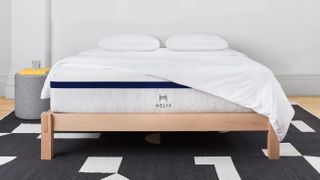 Helix Midnight mattress on a wooden bedframe on a block-pattern carpert