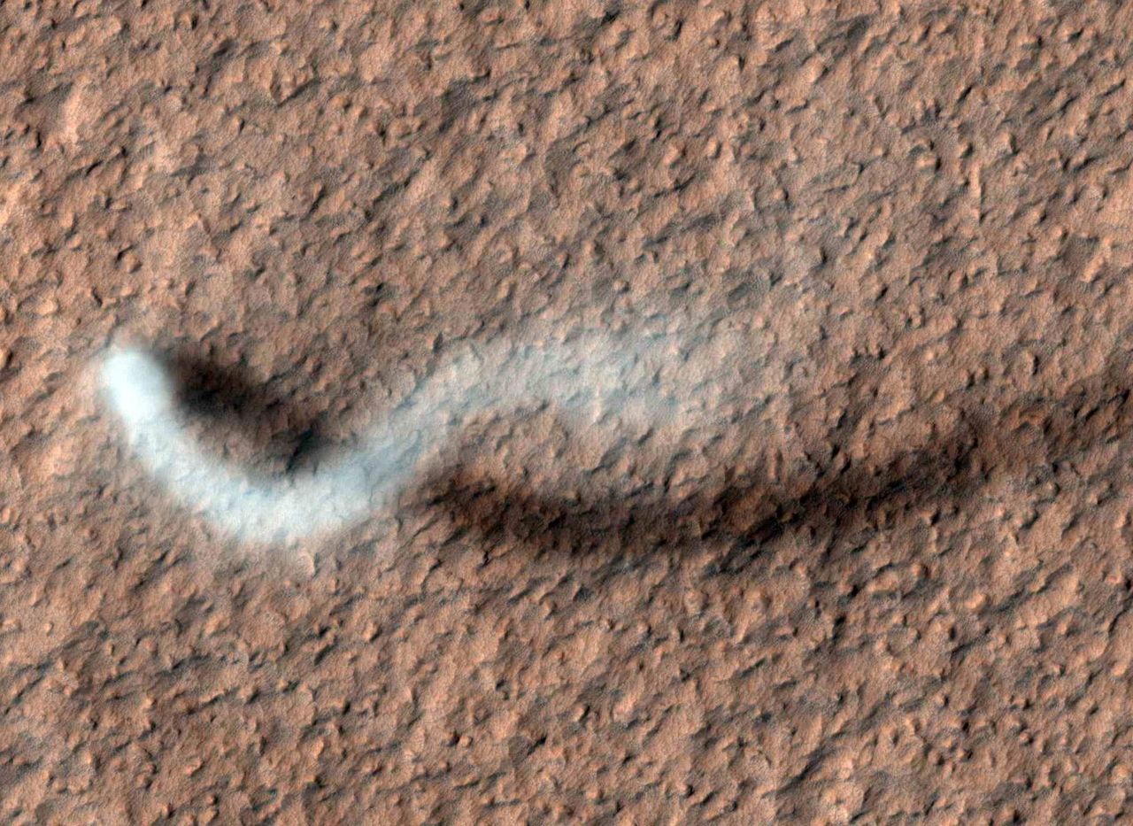 A top-down satellite image of a dust devil swirling across Mars