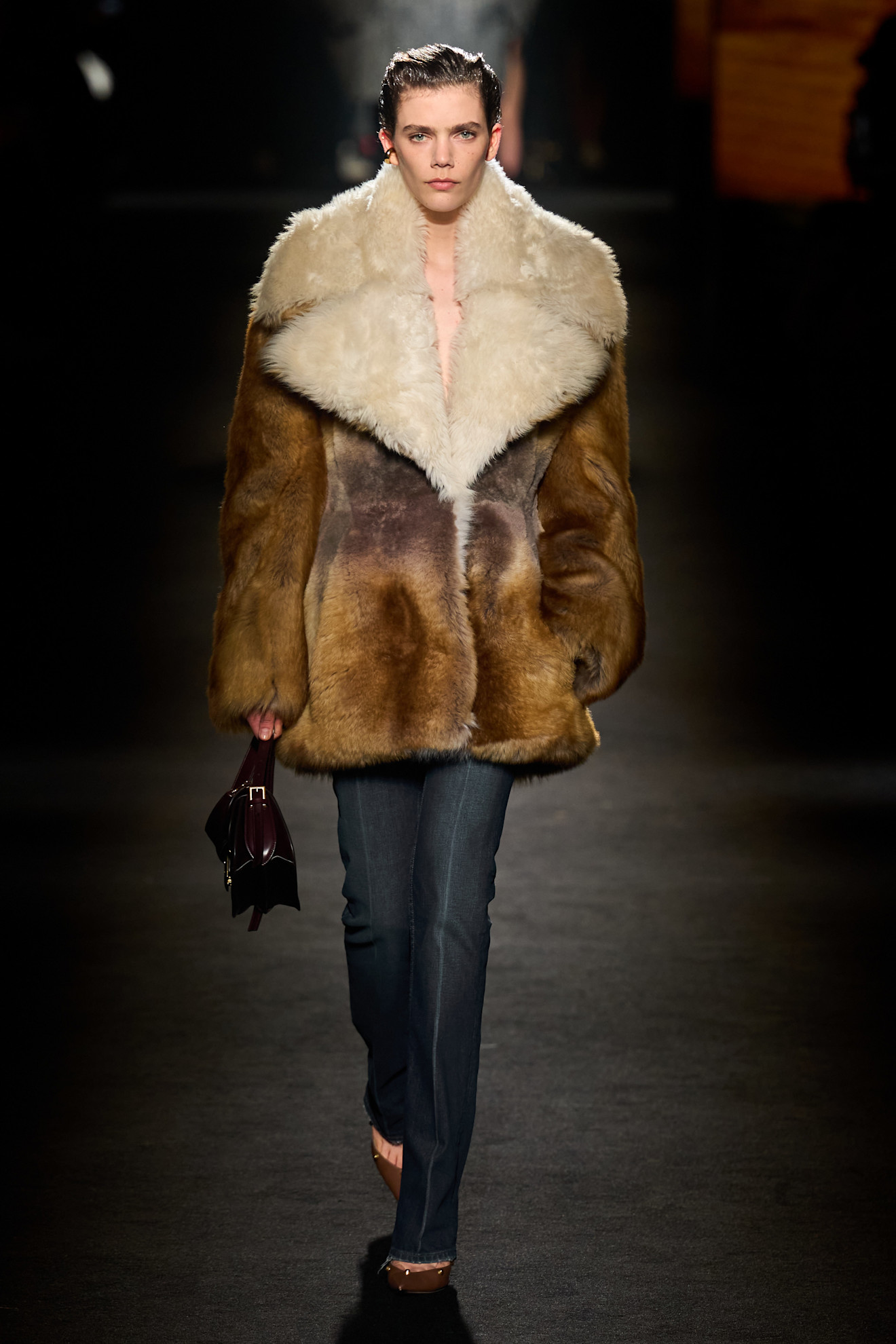A model walking in the F/W 26 Balenciaga show during Paris Fashion Week wearing a fur coat, cigarette jeans, and pumps.