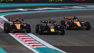 Max Verstappen of Red Bull Racing and Lando Norris and Oscar Piastri of McLaren in a row during a Formula 1 formation lap.