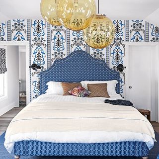 bedroom with blue textured wallpaper and hanging lights