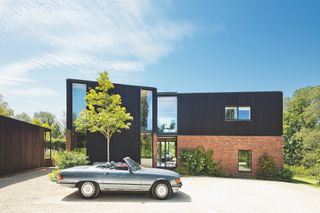 brick and black timber clad self build from the front