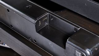 the sony ht-s100f or sony ht-sf150 in uk, a black soundbar with buttons on the top, a remote, photographed with a panasonic TV