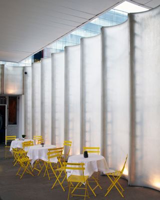 outdoor seating area, framed by the scalloped translucent wall