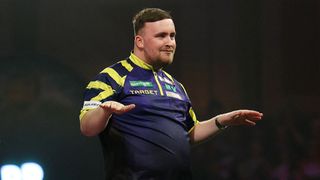Luke Littler puts his arms out like a surfer dude after winning in Round 1 of the PDC World Darts Championship 2026.