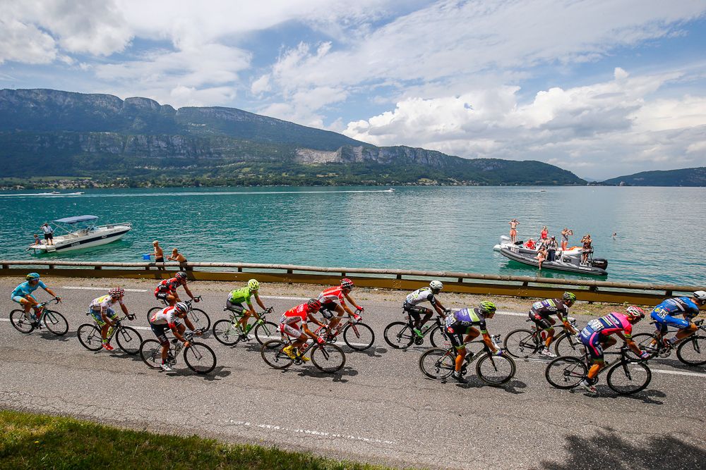 The peloton passes a lake during stage 19 of the Tour de France.