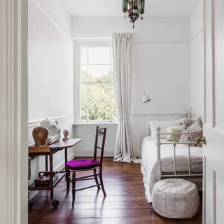 guest bedroom with white walls and wooden flooring