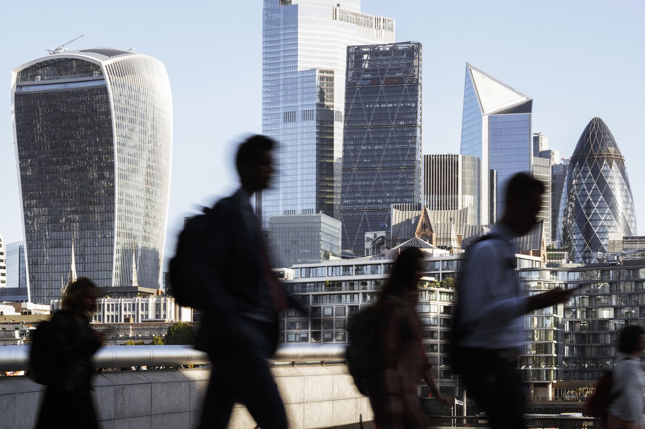 Businesspeople walking in front of the City of London&#039;s skyline