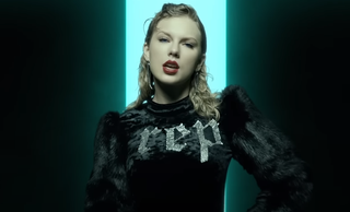 Taylor Swift wearing a sweater that says "rep" in the Look What You Made Me Do music video.
