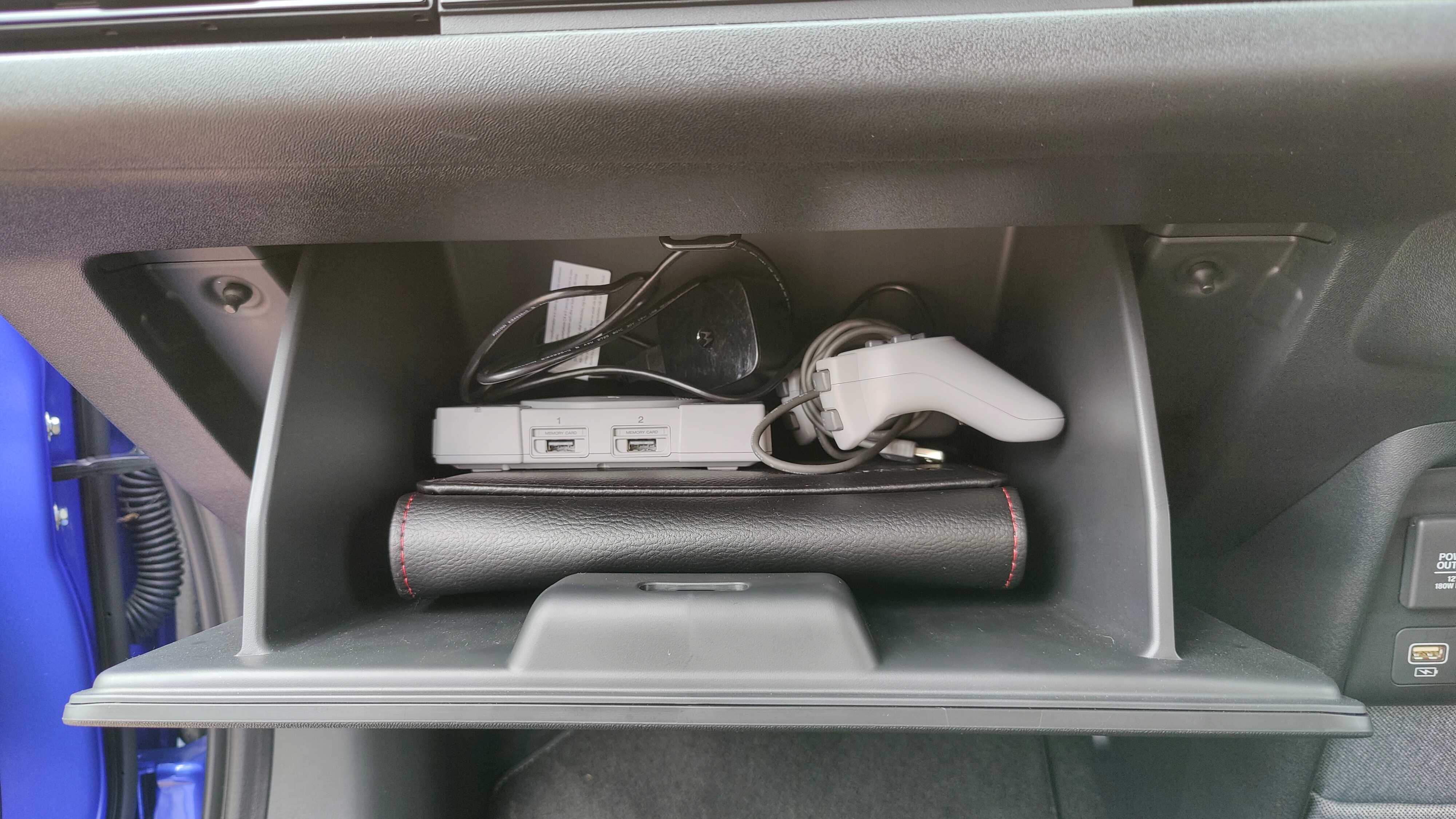 PlayStation Classic and controller in the glove box of the Honda e