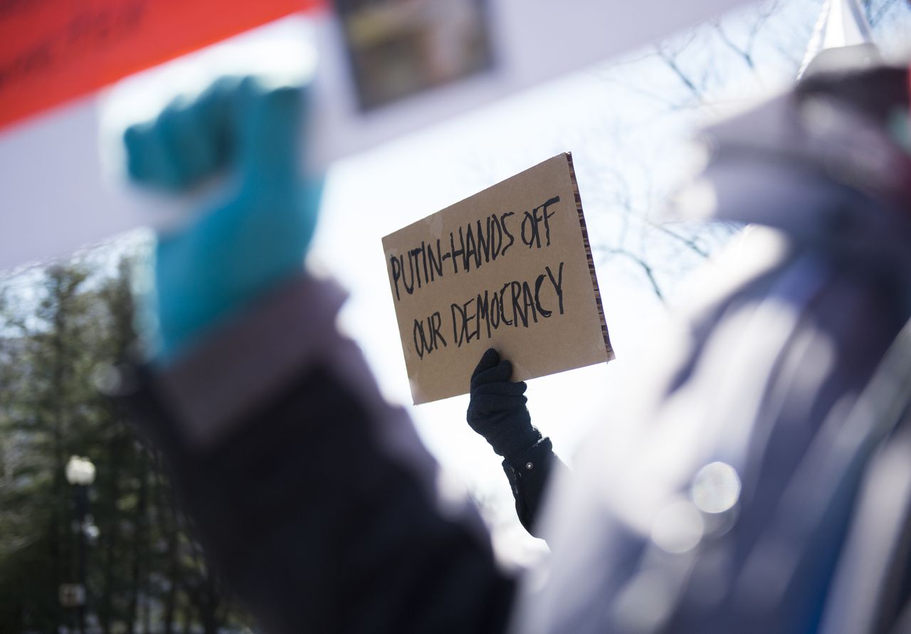 Protesters with signs at the Russia embassy in Washington