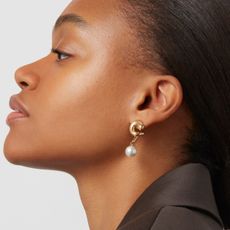 Woman with gaze away from camera wearing pearl sculptural earrings from Jenny Bird. 