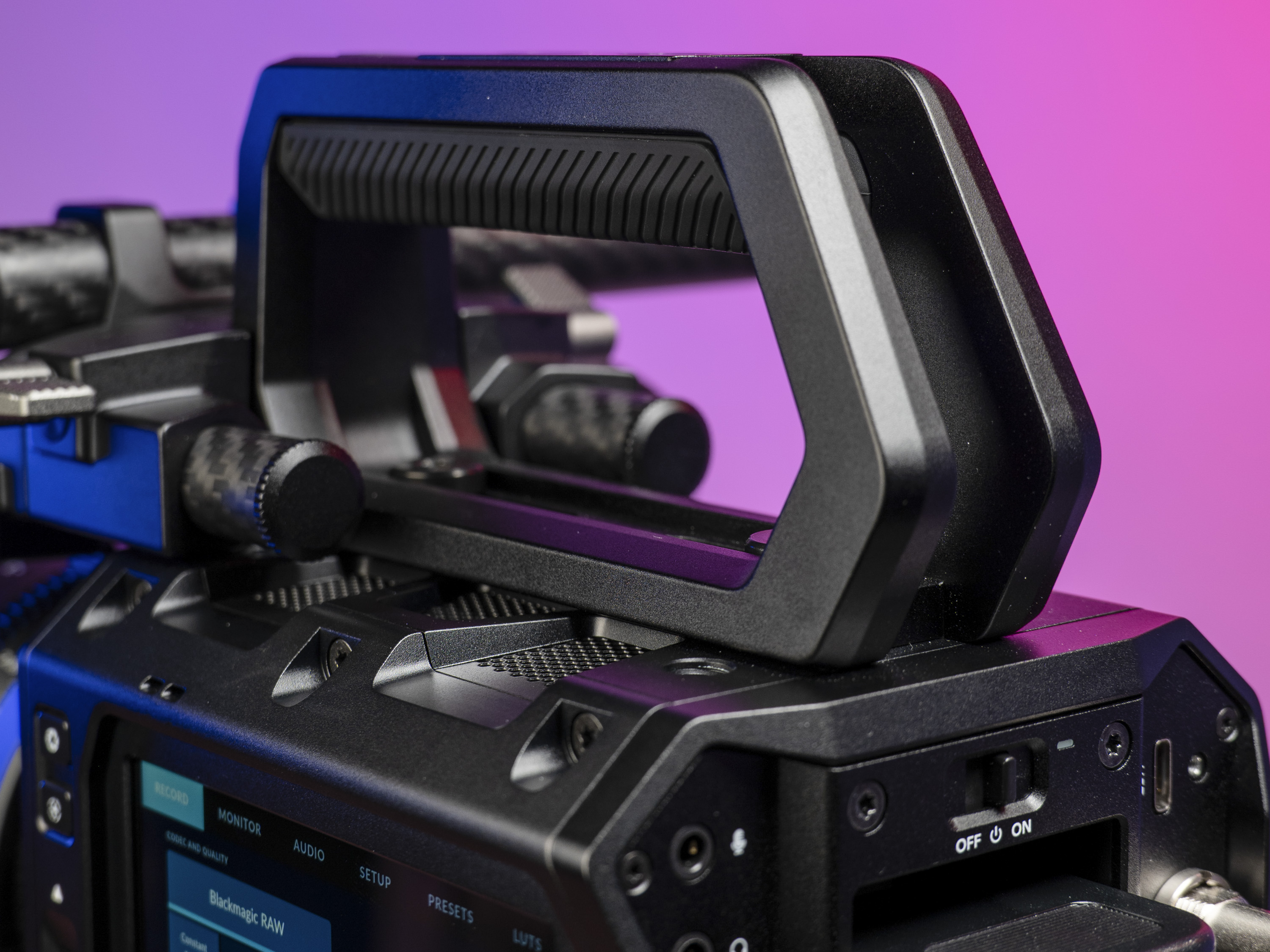 The Blackmagic Pyxis 6K camera's top handle, in the studio with a vibrant magenta background