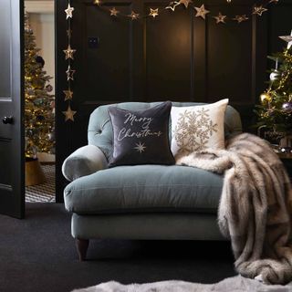 a sharing sofa with cushions and throws and star garlands in the background