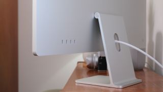 Close-up of the USB-C ports on an Apple iMac on a wooden desk