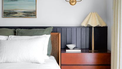 bedroom with nightstand, rattan headboard and lamp with panelling