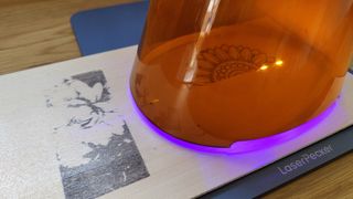 LaserPecker 4 review; a laser beam engraves a piece of wood